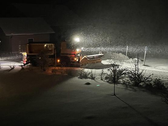 Räumfahrzeug bei Dunkelheit und starkem Schneefall